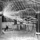 Una de las fotos más míticas de Tesla en el laboratorio de Colorado Springs donde realizaba sus experimentos de recepción a larga distancia. La imagen la tomó el fotógrafo Dickenson Alley mediante exposición múltiple. Vía: Wikipedia